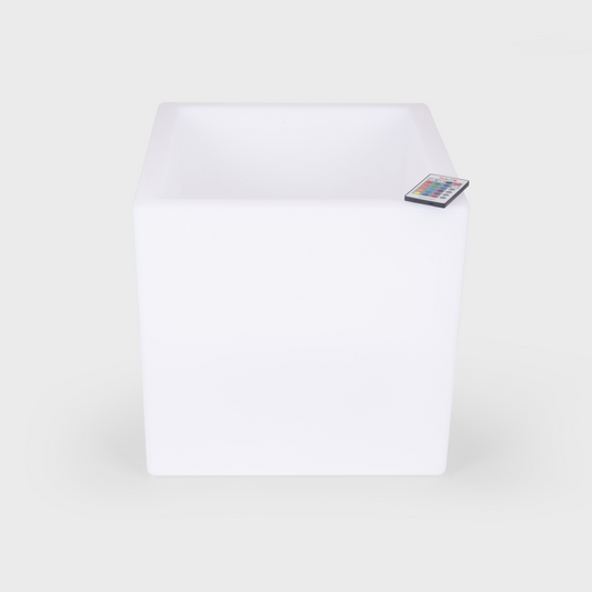 White LED light cube with remote control on a white background
