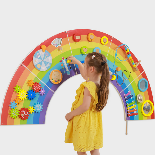 Child interacting with a colourful educational toy shaped like a rainbow on a white background