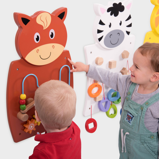 Two children interacting with educational wall toys featuring animal designs.