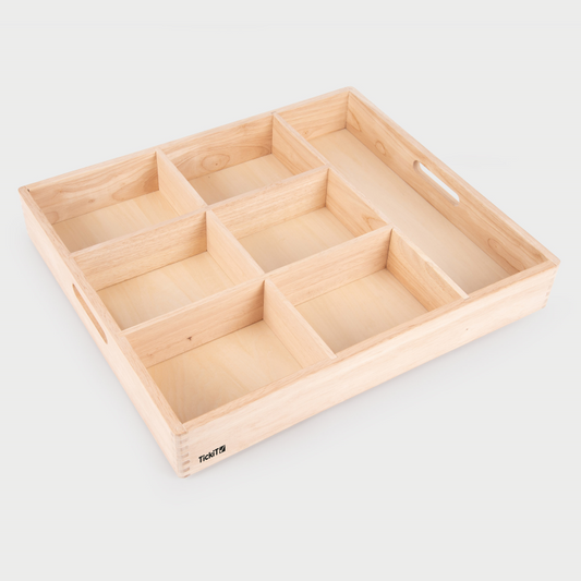 Wooden tray with compartments on a light gray background