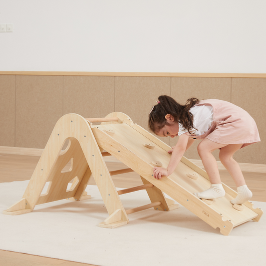 Child playing on a wooden slide indoors