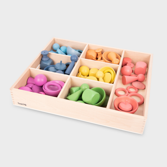 Colorful wooden toys in a wooden box on a light gray background