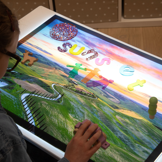 Child playing with a little panel with a play mat on with toys playing