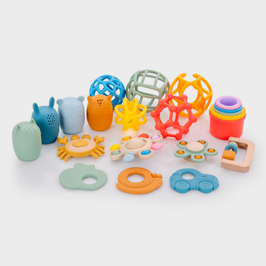 Assorted colourful baby toys on a white background