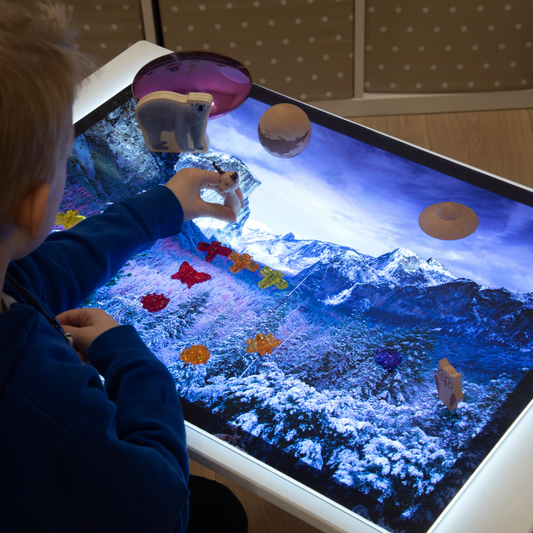 Child interacting with a little panel with a snow mountain scene