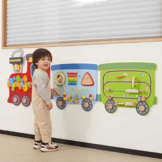 Child interacting with a colorful train-shaped educational board on a wall.