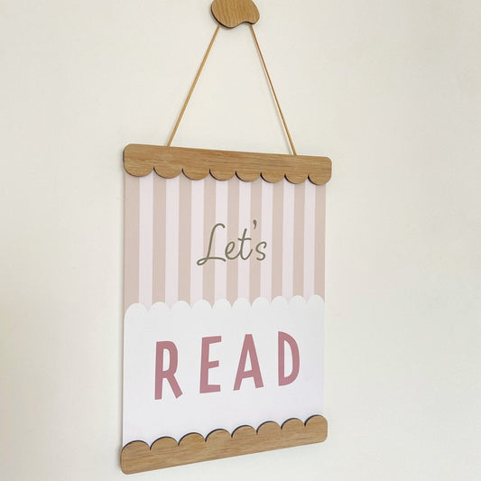 Decorative sign with 'Let's Read' text on a plain background