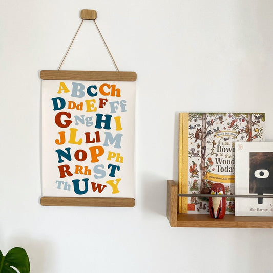 Children's alphabet poster on a wall with books below
