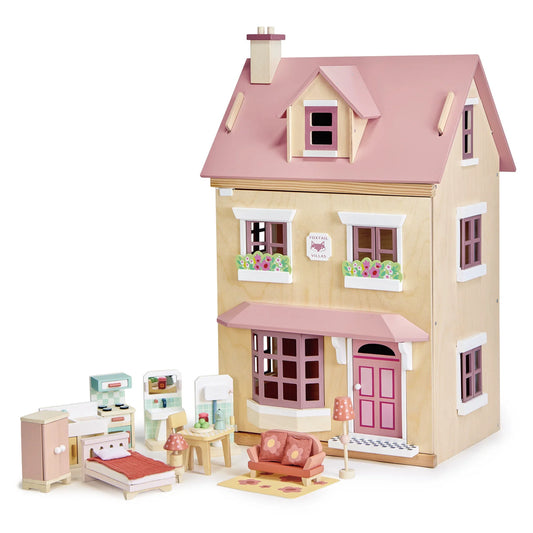 Dollhouse with pink roof and furniture on a white background