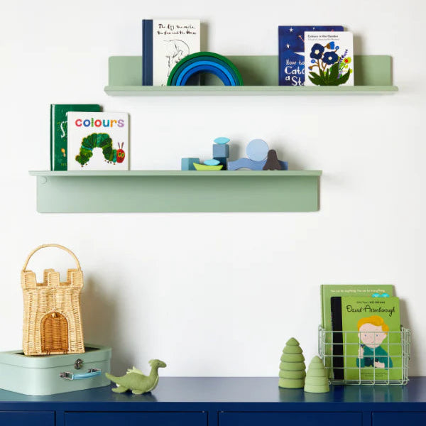 Children's room with green shelves and blue locker, featuring books and toys.