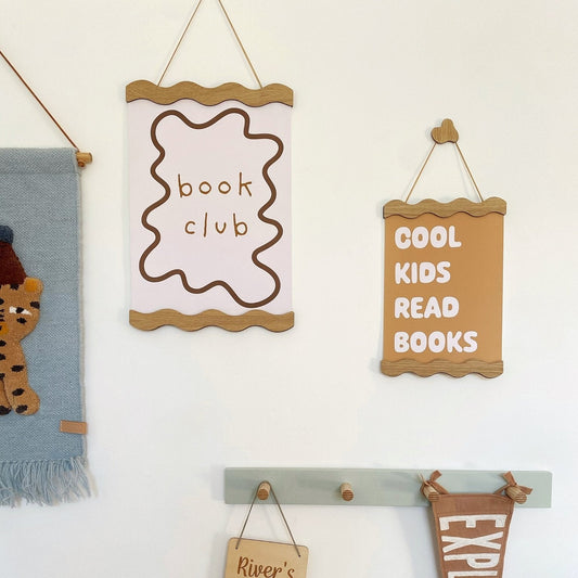 Decorative wall hanging with motivational phrases and a giraffe-themed item.